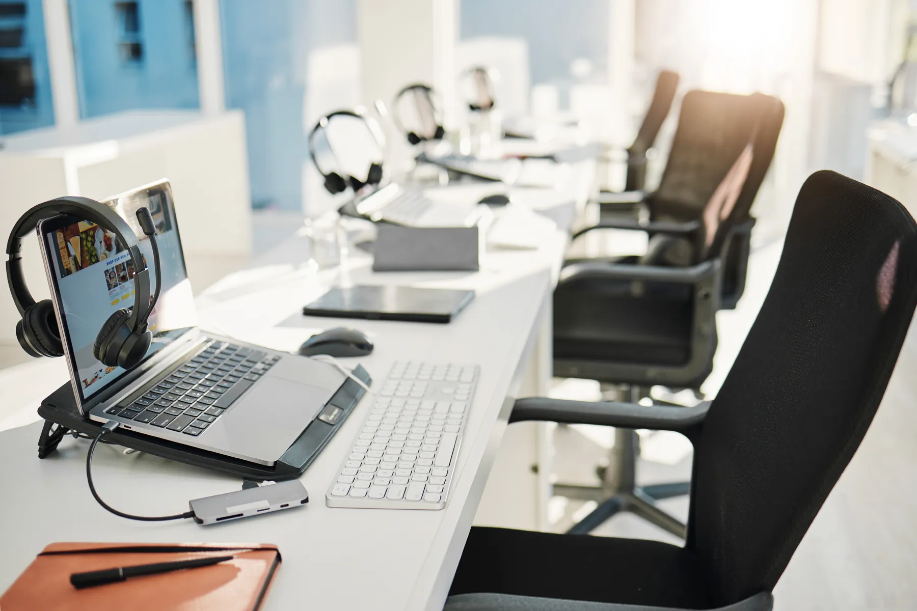 smart-office-arbeitsplatz Schreibtische mit Laptops und Headsets in einem hellen und modernen Büro